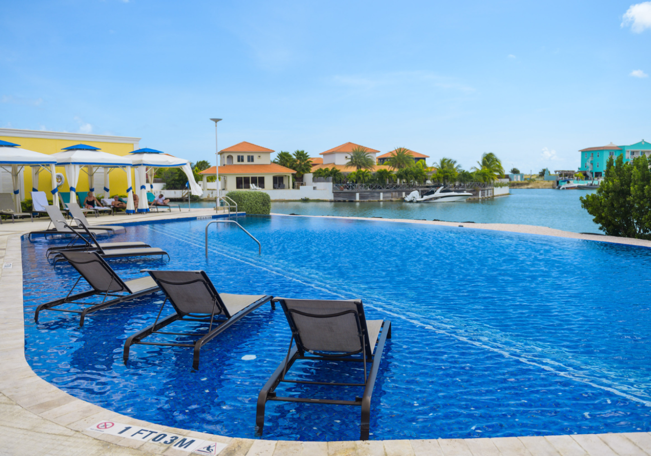 A pool with chairs and a body of water